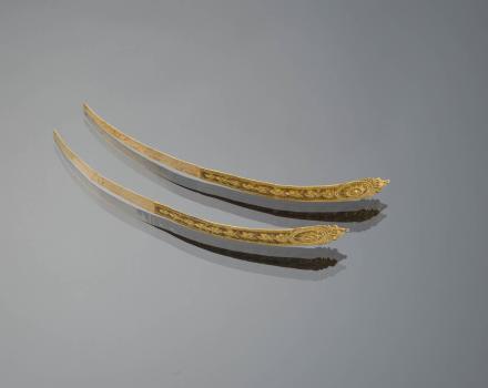 'Zijnaalden'. These were worn as jewelry by pinning them into the cap, so they lay across the forehead. One was worn at a time. These are early 19th century in make.